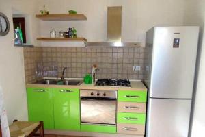 una cucina con mobili verdi e un frigorifero bianco di Basilus ad Acquacalda