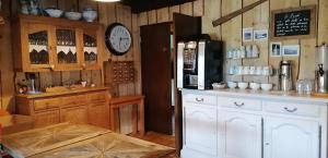 a kitchen with a refrigerator and a clock on the wall at Le Taconet in Le Praz de Lys