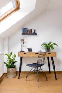 a desk with a chair in a room with plants at Hotel Baroko in Prague