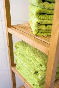 una pila de toallas verdes en un estante de madera en Art City Studio Kassel 2, en Kassel