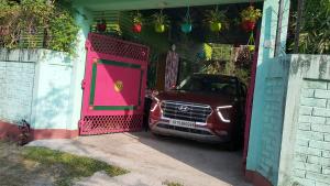 a car parked in a garage with a pink door at GREEN VIEW HOME STAY in Siliguri