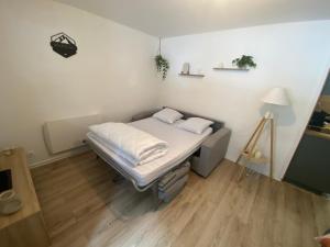 a small bedroom with a bed with white sheets at Appartement au pied des pistes et commerces - 5 personnes in Modane