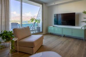 エイラットにあるSea View Suite Eilatのリビングルーム(テレビ、椅子付)