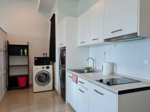 a kitchen with a sink and a washing machine at The Urban Getaway - 118 Tower View in Cyberjaya