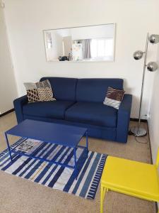 a living room with a blue couch and a table at L'appartement in Le Pradet