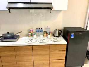 a kitchen with a counter with a stove and a refrigerator at Family room at Apartemen Formosa Residence Nagoya Batam by Wiwi in Nagoya