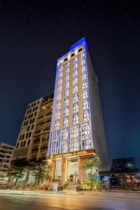 Un edificio alto con una luce blu sopra di Mercy Emerald Hotel a Da Nang