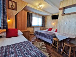 Cette chambre comprend 2 lits et une table. dans l'établissement Pokoje Gościnne ZYNGRA, à Poronin