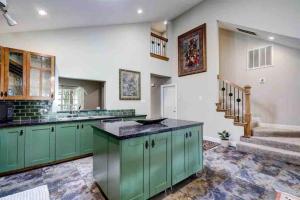 a kitchen with green cabinets and a staircase at Timber Top golf course view in The Woodlands