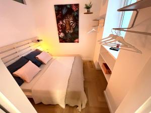 um pequeno quarto com uma cama com um quadro na parede em Boutique Apartment em Viena