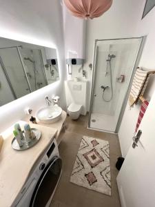 uma casa de banho com um lavatório e um chuveiro. em Boutique Apartment em Viena
