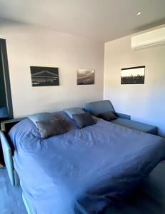 a blue bed in a bedroom with three pictures on the wall at Studio indépendant in Vence
