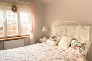 una camera con un letto bianco e un copriletto floreale. di Zacisze nad Sanną 