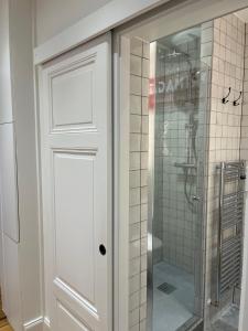 a shower with a glass door in a bathroom at les Gîtes de la limonaderie in Strasbourg