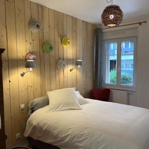 ストラスブールにあるles Gîtes de la limonaderieのベッドルーム1室(木製の壁と窓のあるベッド1台付)