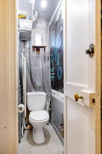 łazienka z toaletą i zasłoną prysznicową w obiekcie Bel appartement à Ile saint Louis, Paris centre w Paryżu