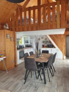 a kitchen and dining room with a wooden table and chairs at Chalet à Cabourg in Cabourg