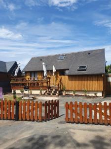 une maison en bois avec une clôture devant elle dans l'établissement Chalet à Cabourg, à Cabourg
