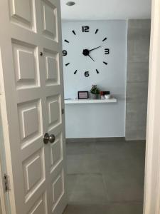 a white door with a clock on a wall at Alojamientos centro in Yecla