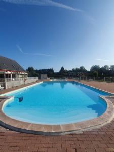une grande piscine d'eau bleue dans l'établissement Chalet à Cabourg, à Cabourg