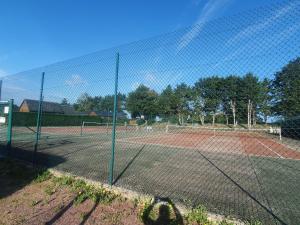 una pista de tenis con red en una pista de tenis en Chalet à Cabourg, en Cabourg