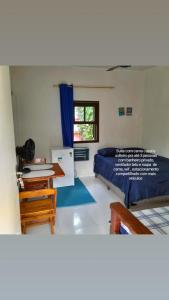 - une chambre avec un lit, un bureau et une table dans l'établissement SUITES E CHALES PRIVADOS Rock's&Rose's home, à Camburi