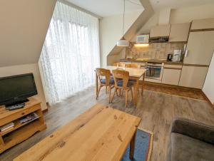 a kitchen and dining room with a table and chairs at Haus Ekke Nekkepenn I, Whg 7 in Wyk auf Föhr
