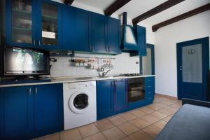 a kitchen with blue cabinets and a washing machine at Sopra La Piazza in Agira