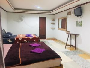 a room with two beds and a television in it at Racha Sunset Resort in Siboya