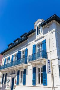 - un bâtiment blanc avec volets bleus dans l'établissement Hotel Edouard VII, à Biarritz