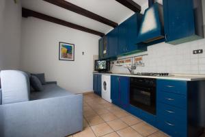 eine Küche mit blauen Schränken und einem Waschbecken in der Unterkunft Sopra La Piazza in Agira