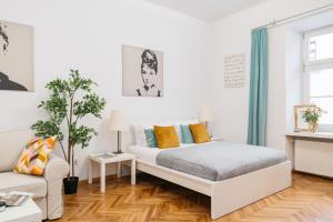 a white bedroom with a bed and a couch at Harmony Studio by LoftAffair in Krakow