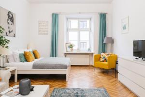 a living room with a bed and a yellow chair at Harmony Studio by LoftAffair in Krakow