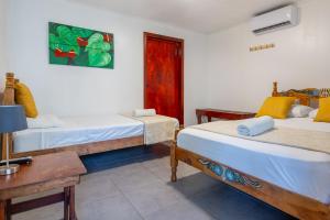 Pokój z 2 łóżkami, biurkiem i stołem w obiekcie La Casona Eco-Lodge Tortuguero w mieście Tortuguero
