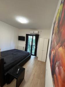 ein Schlafzimmer mit einem Bett und einem Wandgemälde in der Unterkunft MD STUDIO in Novi Sad