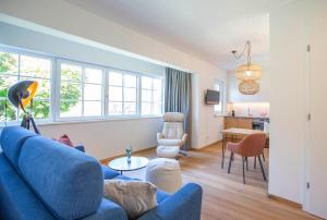 a living room with a blue couch and a table at Refugium Bad Ischl in Bad Ischl