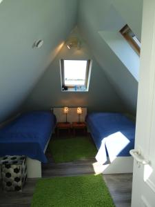 a attic room with two beds and a window at Ferienwohnung Weitblick in Boltenhagen