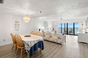 a dining room and living room with a table and a bed at Reflections on the Gulf #503 Beachfront Condo with Pool and Hot Tub in Clearwater Beach