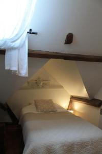 um quarto com uma cama e uma janela com um telhado em Gîte du Rouard em Camiers