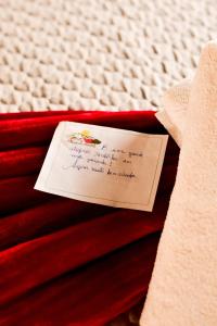 a note sitting on top of a pile of red blankets at Pousada do Nondas in Nobres