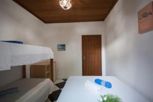 クムルサティバにあるPousada Azul com vistas maravilhosasの白いベッドと木製の天井が備わるベッドルーム1室が備わります。