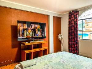 a bedroom with a flat screen tv on a wall at CASITA CHANCHAMAYO in La Merced