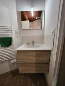 a bathroom with a sink and a mirror at La maison du sabotier in Oradour-Saint-Genest