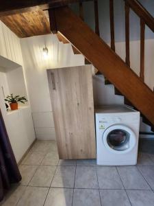 a washing machine in a room with a staircase at La maison du sabotier in Oradour-Saint-Genest