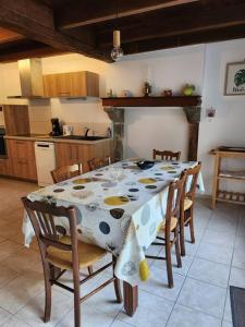 a kitchen with a table with a table cloth on it at La maison du sabotier in Oradour-Saint-Genest