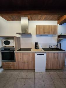a kitchen with a sink and a stove top oven at La maison du sabotier in Oradour-Saint-Genest