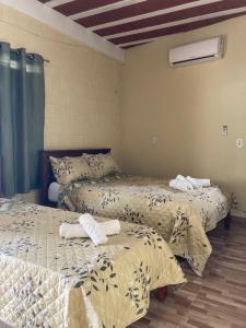 a room with two beds with towels on them at Pousada Vitória in Pitimbu