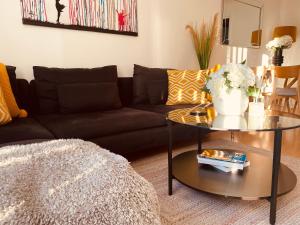 ein Wohnzimmer mit einem Sofa und einem Tisch in der Unterkunft 2 Bed town house with Garden in Hackney, London in London