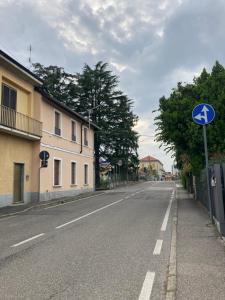 an empty street with a blue sign on the side of the road at Casa Nova Luxury Apartment Suite Limoni in Nova Milanese