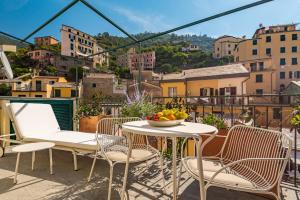 een balkon met stoelen en een tafel met een fruitschaal bij La Vista di Marina by The First in Riomaggiore